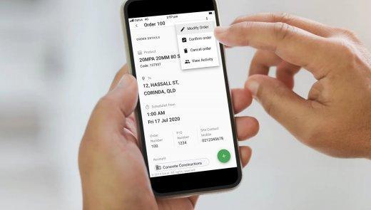 man holding phone with boral connects open